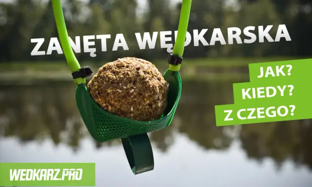 Kula zanęty wędkarskiej 5 kg w zielonej łopatce, gotowa do zarzucenia. W tle woda i drzewa.