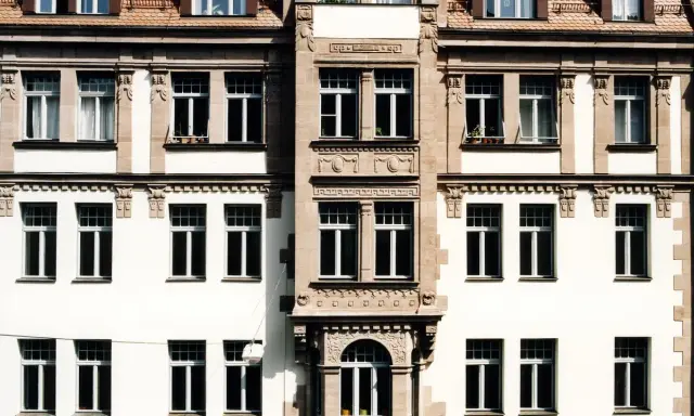 Fassade eines Altbaus mit vielen Fenstern. Hier könnte eine energetische Sanierung Beratung ansetzen, um das Gebäude fit für die Zukunft zu machen.