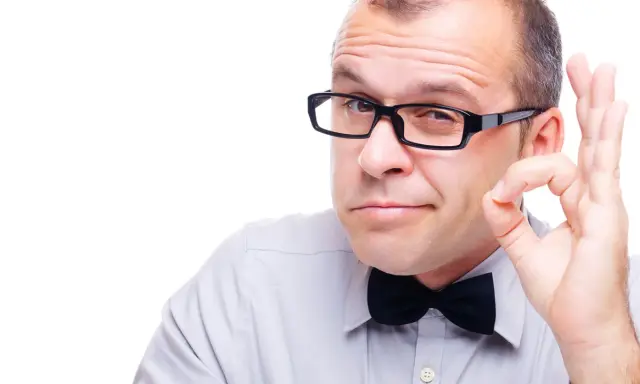 Mężczyzna w okularach i muszce pokazuje gest "OK". Okulary leżą idealnie na nosie, podkreślając jego pewność siebie.