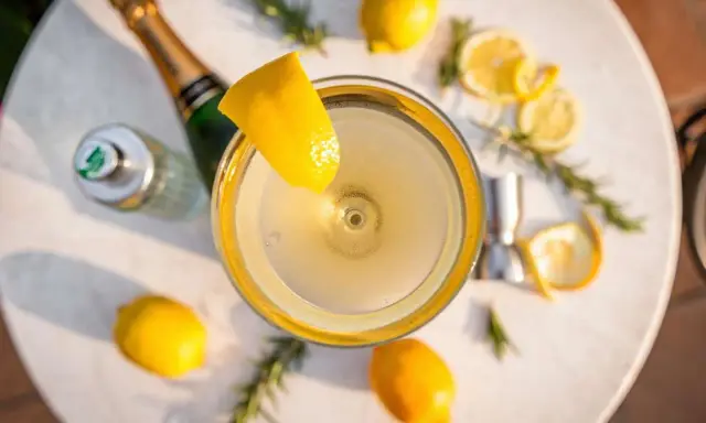 Ein erfrischender French 75 Cocktail mit Zitrone und Rosmarin. Das perfekte Rezept für einen Aperitif.