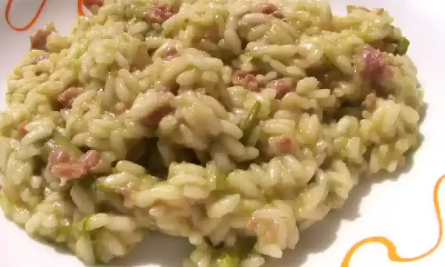 Un cremoso risotto asparagi e salsiccia, un piatto ricco di sapore e colore, pronto per essere gustato.