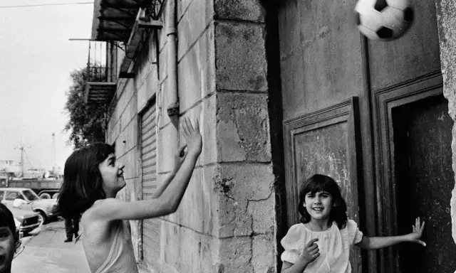 Bambine giocano a pallone in strada, un momento catturato da una fotografa famosa italiana.