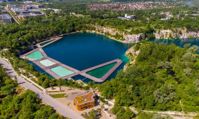 Widok z lotu ptaka na zalew Zakrzówek z drewnianymi pomostami i basenami. Trasa spacerowa wokół zbiornika.