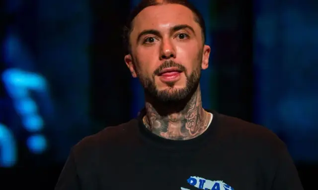 Malik Montana, z tatuażami na szyi, pokazuje język. Ile lat ma Malik Montana?