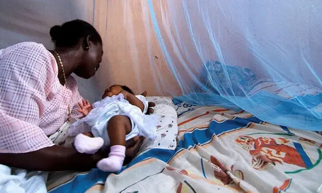 Mor och barn under myggnät, skyddade från malaria. Bali är en plats där kampen mot malaria fortsätter.
