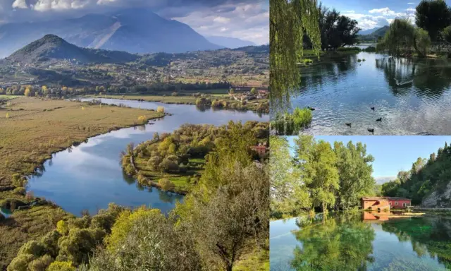 Paesaggio incantevole del lago di Posta Fibreno, con montagne sullo sfondo, un fiume serpeggiante e un antico mulino rosso riflesso nelle acque cristalline.