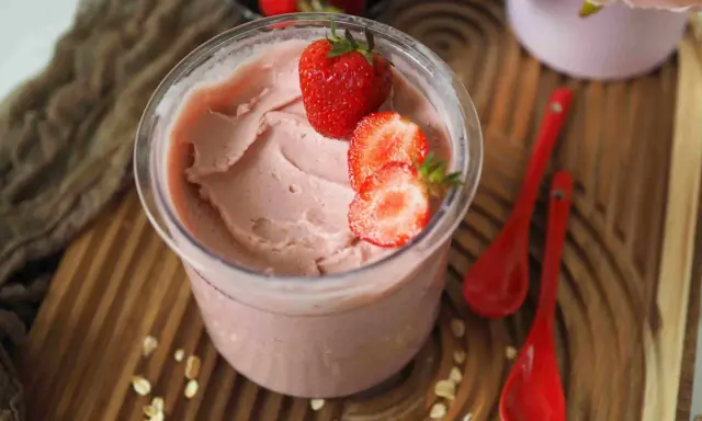 Cremiges Kefir Eis mit frischen Erdbeeren garniert, bereit zum Genießen.