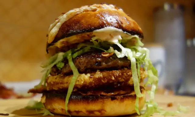 Apetyczny burger drwala przepis: podwójna wołowina, chrupiący panierowany kotlet, sałata i sos na puszczy.