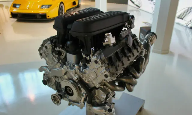 Silnik Lamborghini V10. Zapchany smok olejowy objawy mogą prowadzić do uszkodzenia. W tle żółty sportowy samochód.