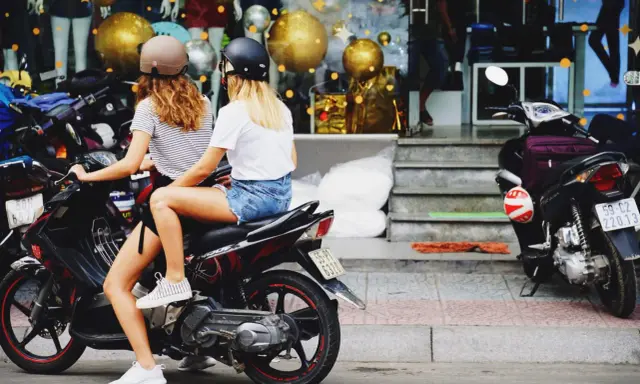 Dos chicas con cascos en una moto, listas para sacar carnet moto y disfrutar de la libertad.