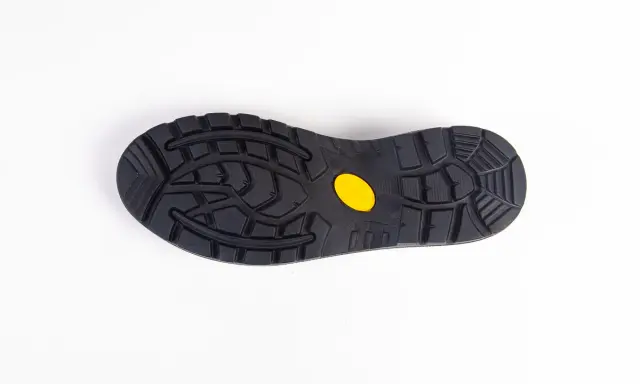Czarna podeszwa buta z żółtym logo Vibram, gotowa do wymiany w butach, zapewniająca przyczepność.