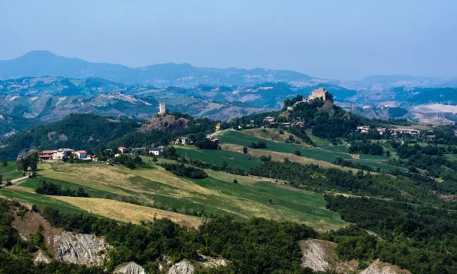 Paesaggio collinare con borghi e torri, ideale per esplorare i sentieri dell'Appennino Tosco Emiliano.