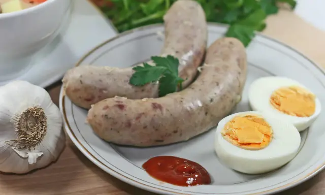 Biała kiełbasa z jajkiem i ketchupem, obok czosnek i natka. Idealne dodatki, jakie przyprawy do białej kiełbasy?