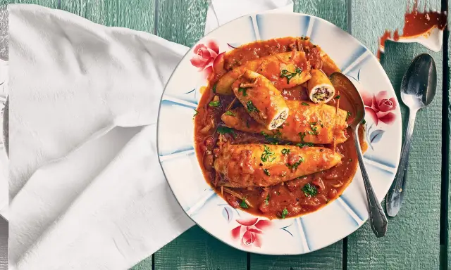 Assiette de calamars farcis à la sauce tomate, une recette encornet tomate savoureuse, garnie de persil frais.