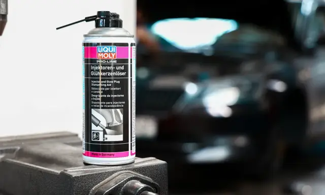 Puszka preparatu do czyszczenia wtryskiwaczy Liqui Moly na tle rozmazanego silnika.