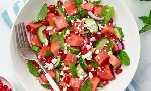Salade estivale de pastèque, concombre, feta émiettée, grenade et menthe fraîche. Un délice rafraîchissant.