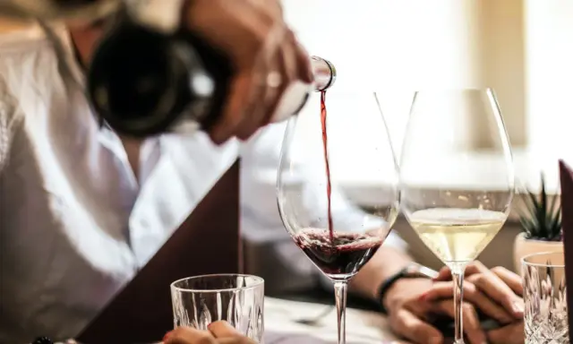 Servicio de vino tinto en la finca la malcriada dulce. Copas de vino y agua en una mesa elegante.