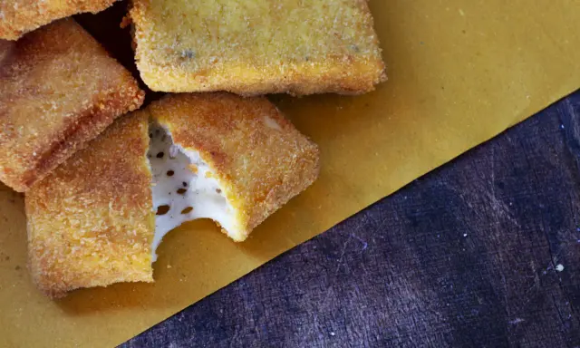 Mozzarella in carrozza dorata e croccante, con il formaggio filante che fuoriesce da uno spicchio.