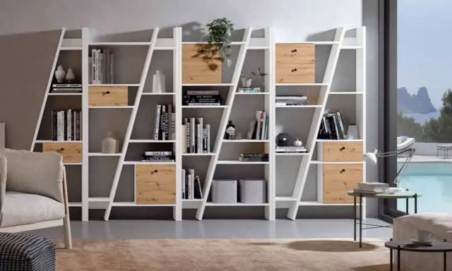 Estanterías blancas con cajones de madera, llenas de libros y objetos decorativos. La decoración de estanterías es clave para un hogar moderno.