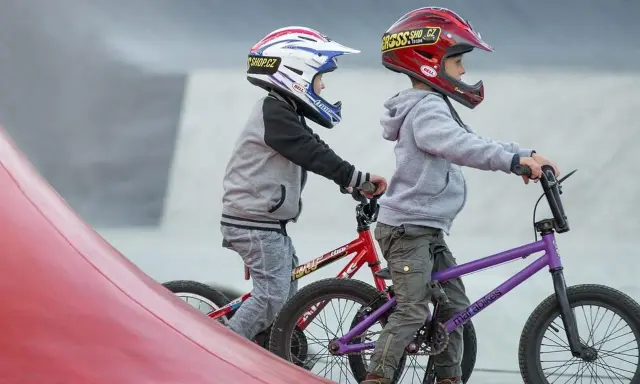 Dwóch chłopców w kaskach na rowerach BMX gotowych do zjazdu. Idealne rzeszów atrakcje dla dzieci do aktywnego spędzania czasu.
