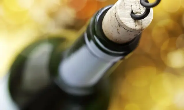Korek wyciągany korkociągiem z butelki wina. Czyżby szykował się wieczór z alkoholem na poziomie 4 promile?