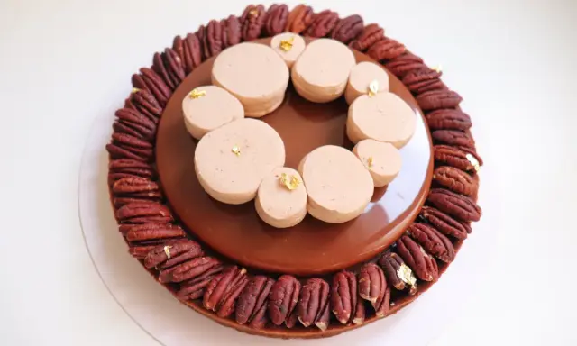 Tarte chocolat noix de pécan, un délice gourmand avec une ganache brillante et des touches de feuille d'or.