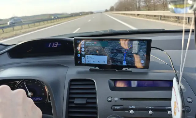 Na ekranie w samochodzie widać nawigację z funkcją co to jest carplay. Pokazuje trasę, odległość i czas dojazdu.