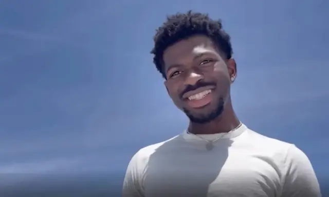 Lil Nas X, uśmiechnięty na tle błękitnego nieba. Czy Lil Nas X jest gejem? To pytanie często pojawia się w dyskusjach o jego życiu.