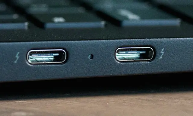 Dwa porty Thunderbolt 4 na obudowie laptopa, gotowe do szybkiego transferu danych i ładowania.