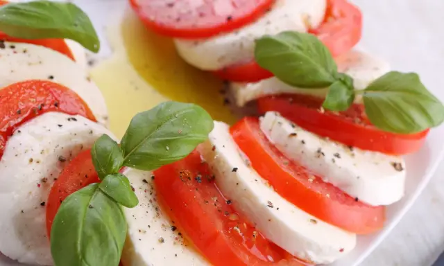 Sałatka z mozzarellą, pomidorami i bazylią, skropiona oliwą i pieprzem. Klasyczne połączenie smaków.