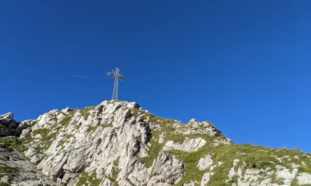 Kamienista trasa na Giewont prowadzi pod górę, gdzie widać krzyż na szczycie.