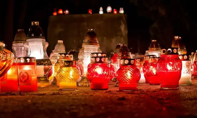 Płonące znicze na cmentarzu. Warto pamiętać, dlaczego nie wolno palić zniczy na pogrzebie, by nie zakłócać spokoju zmarłych.