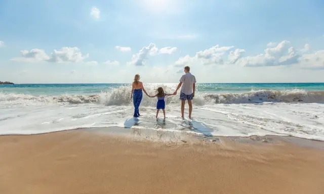 Familia disfrutando de un día en la playa de Altea con niños, jugando entre las olas.