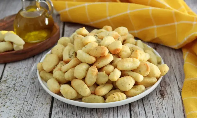 Gnocchi dorati e croccanti, preparati in friggitrice ad aria, conditi con erbe aromatiche.