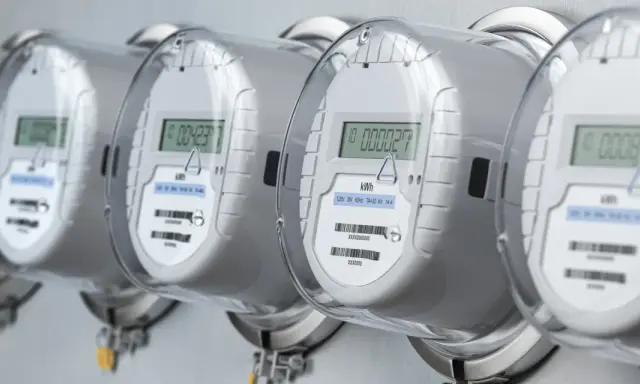 Rząd nowoczesnych liczników dwukierunkowych z cyfrowymi wyświetlaczami, gotowych do monitorowania zużycia energii.