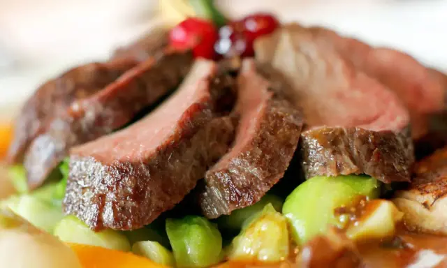 Saftiges Wildfleisch, zart geschnitten, mit knackigem Gemüse und Beeren garniert. Eine köstliche Antwort auf die Frage: Ist Wildfleisch gesund?