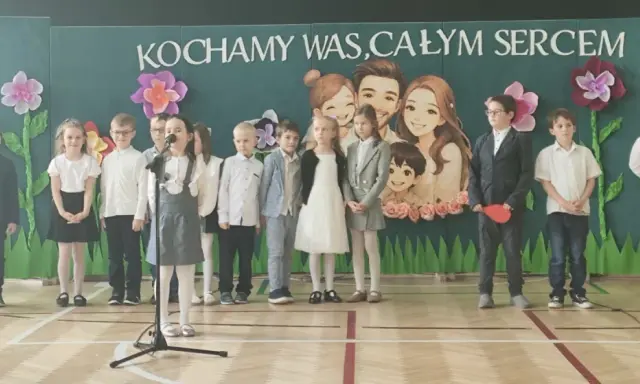 Dzieci śpiewają piosenkę na komunię dla rodziców. Tekst piosenki jest pełen miłości.