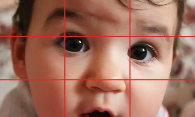 Primo piano di un bimbo con griglia della regola dei terzi. Gli occhi sono posizionati sui punti di intersezione, creando ritratti efficaci.