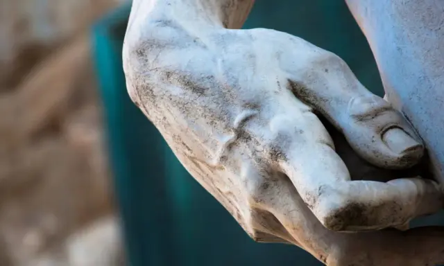 Main d'une statue de David à Florence, marbre patiné par le temps.