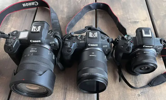 Trzy aparaty Canon EOS R z różnymi obiektywami, w tym jeden z trybem obrazu APS.