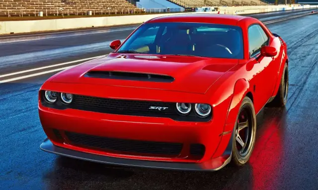 Czerwony Dodge Challenger Demon na torze wyścigowym, gotowy do startu.