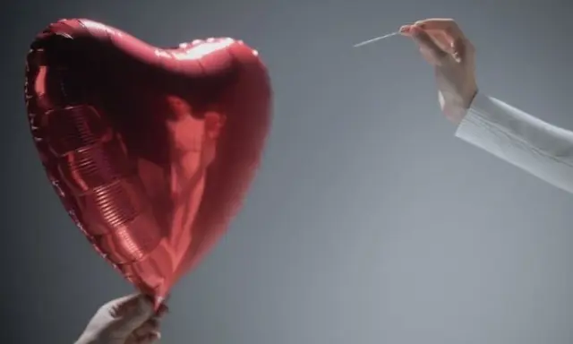 Czerwone serce-balon trzymane w dłoni, druga dłoń z igłą zbliża się do niego. Symbolizuje współżycie w trakcie rozwodu, które jest na skraju pęknięcia.