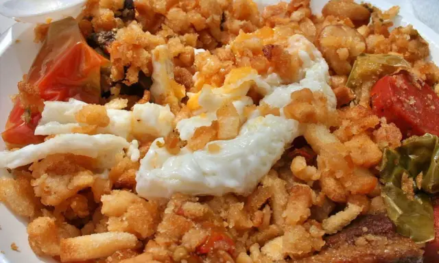 Plato de migas con huevo frito, pimientos y tomate, un delicioso ejemplo de comida típica de Jaén.