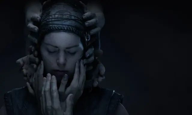 Senua w Hellblade 2 otoczona przez dłonie, jej twarz wyraża cierpienie.