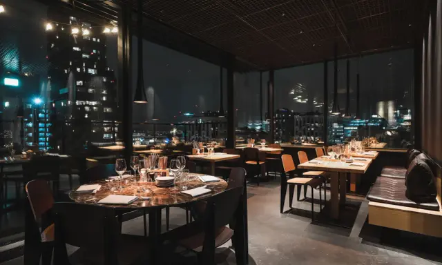 En mysig restaurang i Stockholm med vacker utsikt över stadens ljus på natten. Eleganta bord med dukning och bekväma sittplatser.