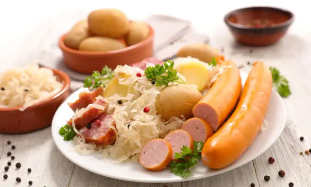 Assiette de choucroute garnie, pommes de terre et saucisses, un classique de la gastronomie alsace.