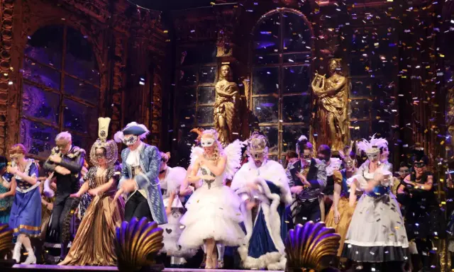Scena z "Upiora w Operze" – barwny bal maskowy z konfetti.