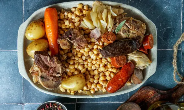 Un plato generoso para comer cocido en pueblos de Madrid: garbanzos, patatas, zanahoria, carnes y embutidos.