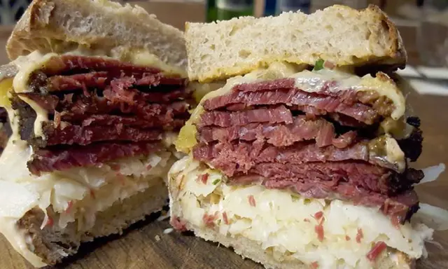 Pyszny reuben sandwich z grubymi plastrami wołowiny, kiszoną kapustą i serem, podany na chlebie żytnim.