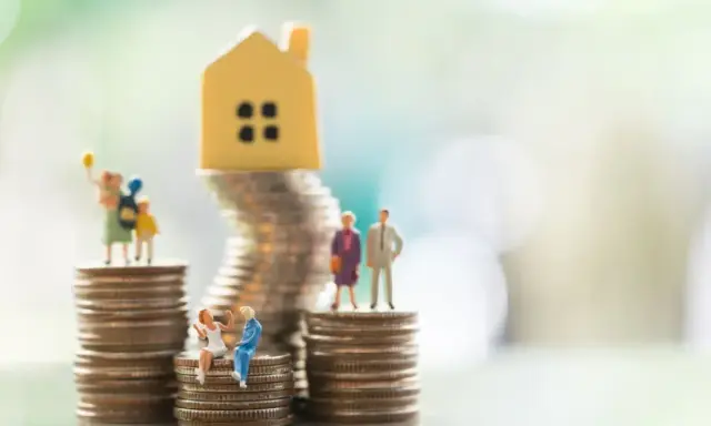 Miniaturowe figurki ludzi i domku na stosach monet. Symbolizują różne modele rodziny, w tym rodzinę patchworkową, i ich sytuację finansową.